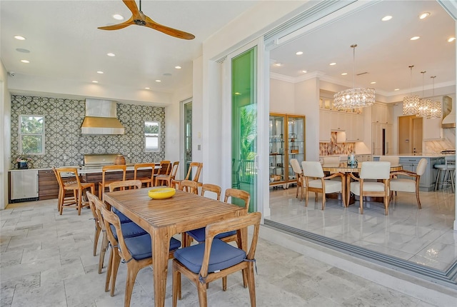 dining area featuring ceiling fan with notable chandelier and crown molding