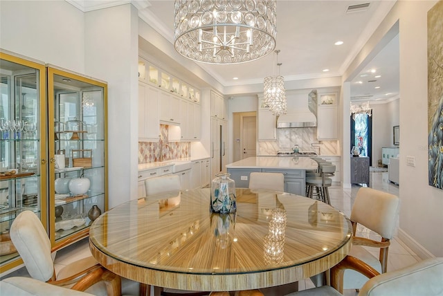 dining area featuring light tile patterned floors, crown molding, a notable chandelier, and sink