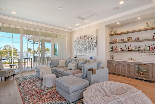 living room featuring light hardwood / wood-style flooring, beverage cooler, indoor bar, and ornamental molding