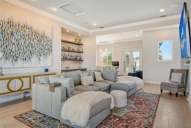 living room with bar area, light wood-type flooring, and crown molding