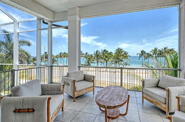 sunroom / solarium with a water view and a view of the beach