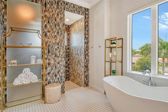 bathroom with tile patterned flooring, ornamental molding, and a tub