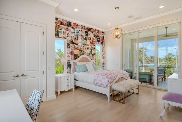 bedroom featuring access to exterior, a closet, light wood-type flooring, and ornamental molding