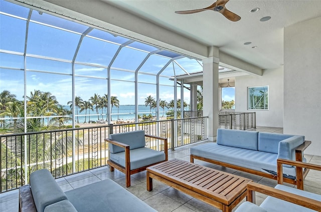 view of patio / terrace featuring an outdoor living space, ceiling fan, a water view, and a beach view