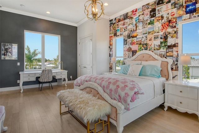 bedroom featuring a closet, light hardwood / wood-style flooring, multiple windows, and a notable chandelier