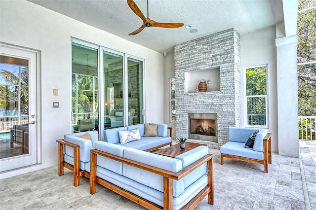 view of patio / terrace featuring an outdoor living space with a fireplace and ceiling fan