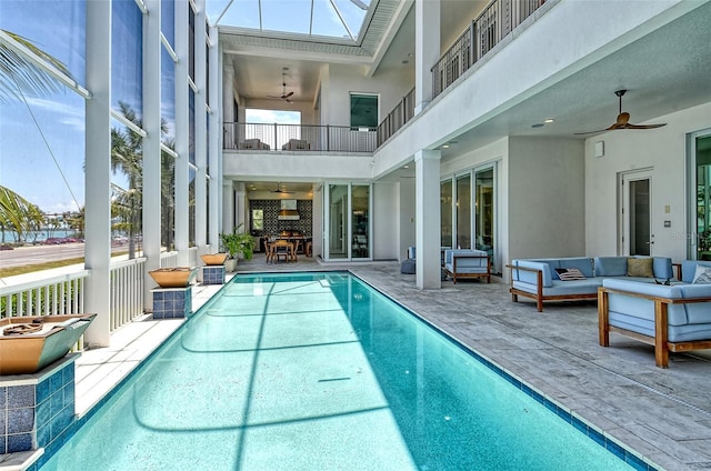 view of pool featuring outdoor lounge area, a patio, and ceiling fan