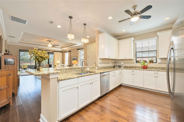 kitchen featuring white cabinetry, sink, kitchen peninsula, pendant lighting, and wood-type flooring