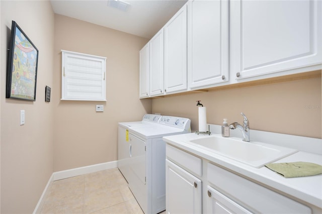 laundry area featuring cabinets, light tile patterned flooring, washing machine and dryer, and sink