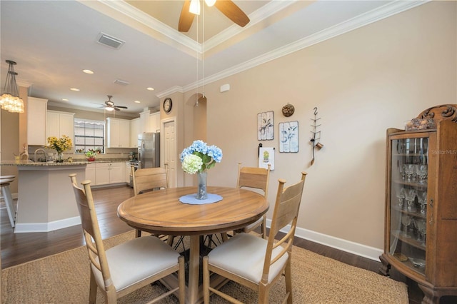 dining space featuring crown molding, dark hardwood / wood-style flooring, ceiling fan, and sink