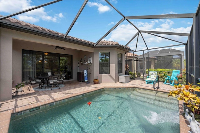 view of swimming pool with a patio area, ceiling fan, and glass enclosure