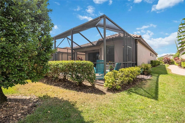 rear view of house with a lanai and a yard