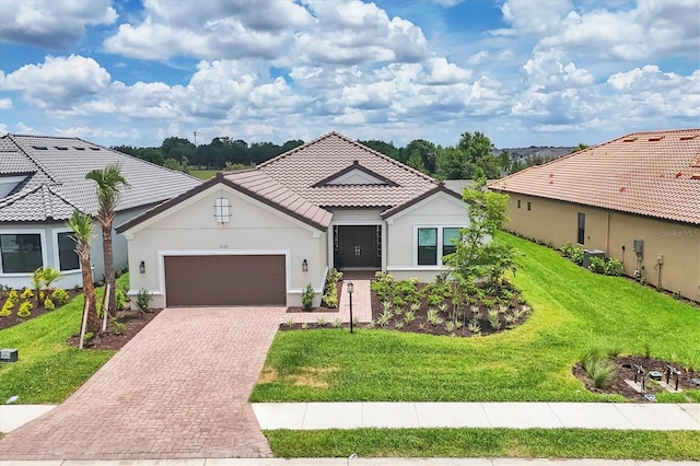 mediterranean / spanish-style home featuring a garage and a front lawn