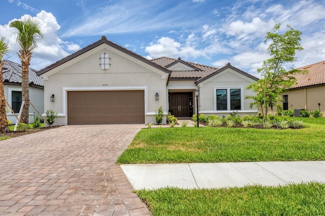 mediterranean / spanish house featuring a front yard and a garage