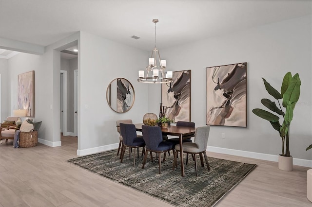 dining area featuring light hardwood / wood-style floors and an inviting chandelier