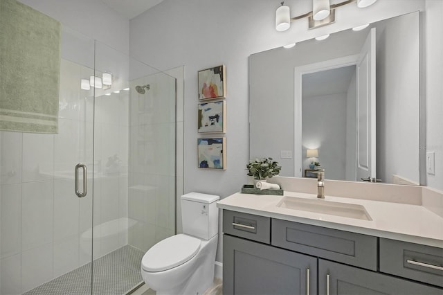 bathroom featuring a shower with door, vanity, and toilet