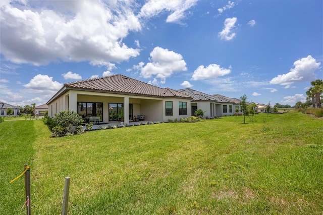 rear view of house featuring a lawn