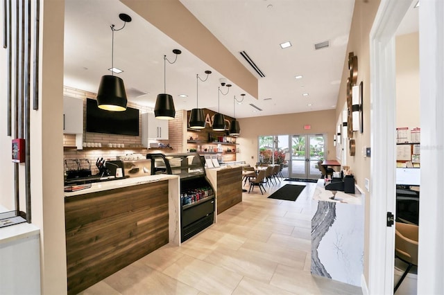 kitchen featuring decorative light fixtures, tasteful backsplash, light tile patterned floors, and french doors