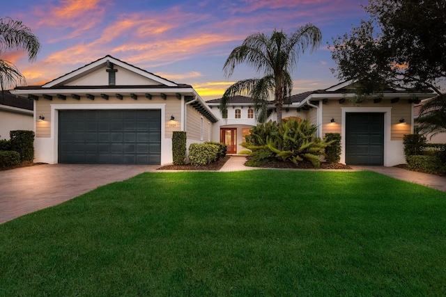 single story home featuring a lawn, a garage, and french doors