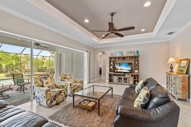 living room featuring a raised ceiling, light hardwood / wood-style floors, and ornamental molding