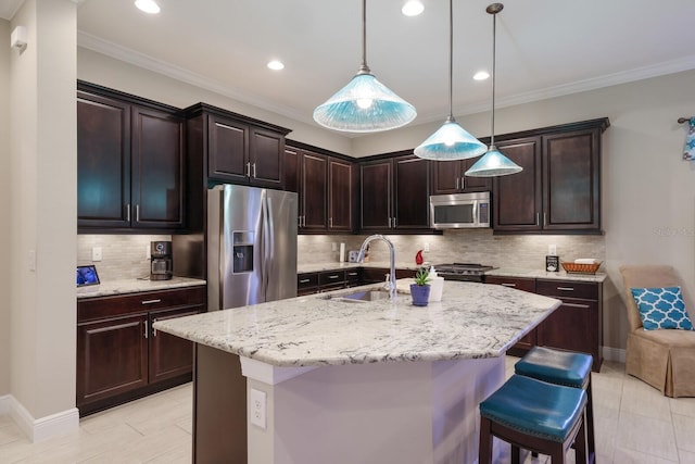 kitchen with dark brown cabinets, stainless steel appliances, a kitchen island with sink, pendant lighting, and a breakfast bar area