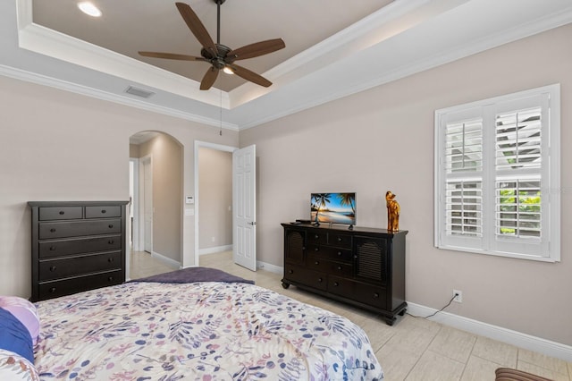 bedroom featuring a raised ceiling, ceiling fan, and ornamental molding