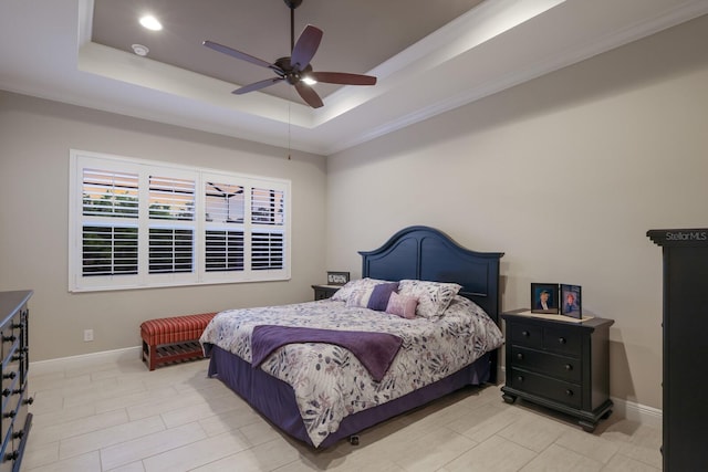 bedroom with a raised ceiling and ceiling fan