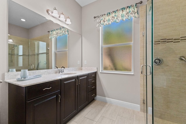 bathroom featuring vanity, a shower with door, and a wealth of natural light