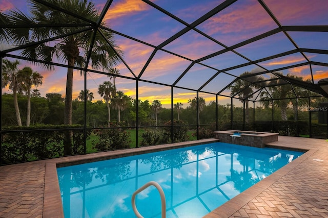 pool at dusk with an in ground hot tub and glass enclosure