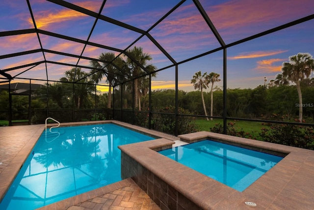 pool at dusk with a lanai and a patio