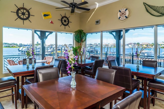 tiled dining room featuring ceiling fan, a healthy amount of sunlight, a water view, and crown molding