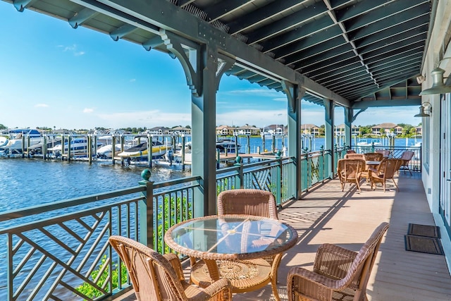 balcony with a water view and a dock