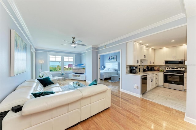 living room with ceiling fan, light hardwood / wood-style flooring, sink, and ornamental molding