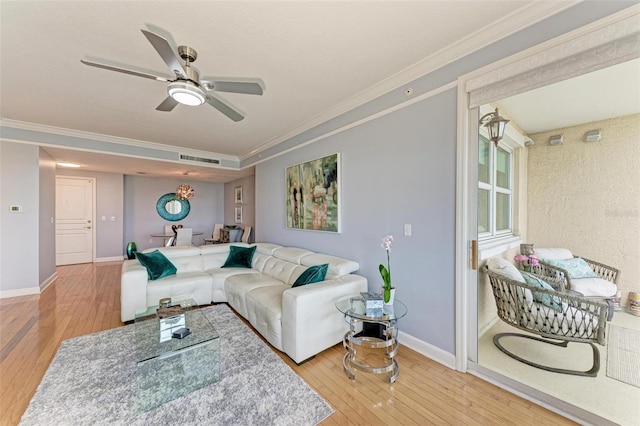 living room with ceiling fan, wood-type flooring, and ornamental molding