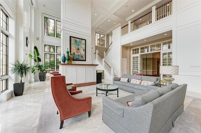 living room with a high ceiling, ornamental molding, coffered ceiling, and beam ceiling