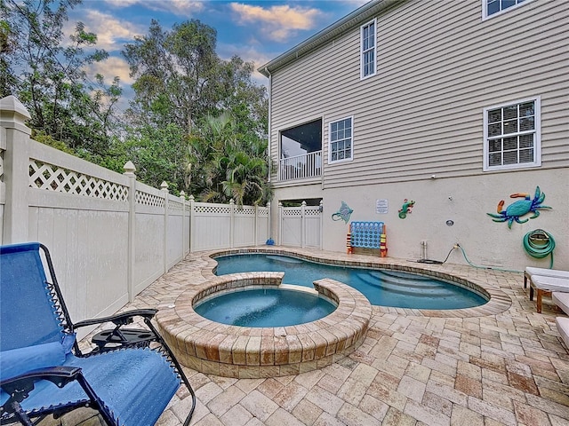 view of pool with a patio area and an in ground hot tub