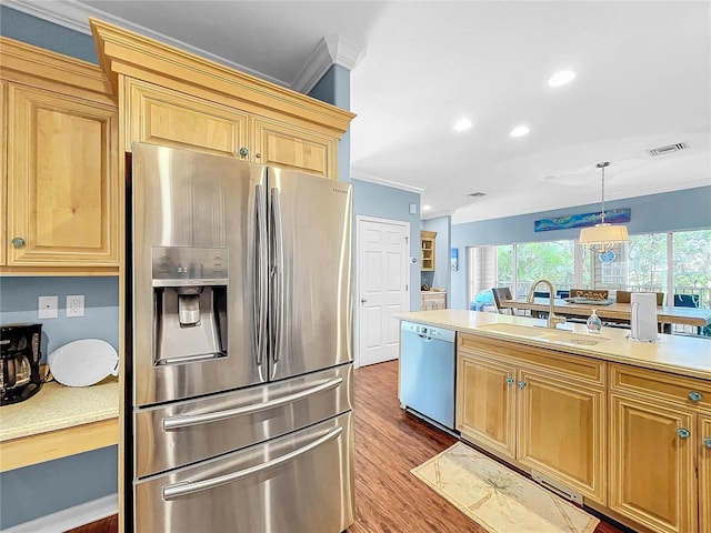 kitchen with stainless steel appliances, ornamental molding, sink, and pendant lighting