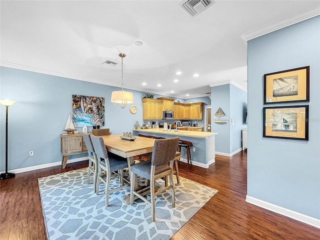 dining room with crown molding and dark wood-type flooring