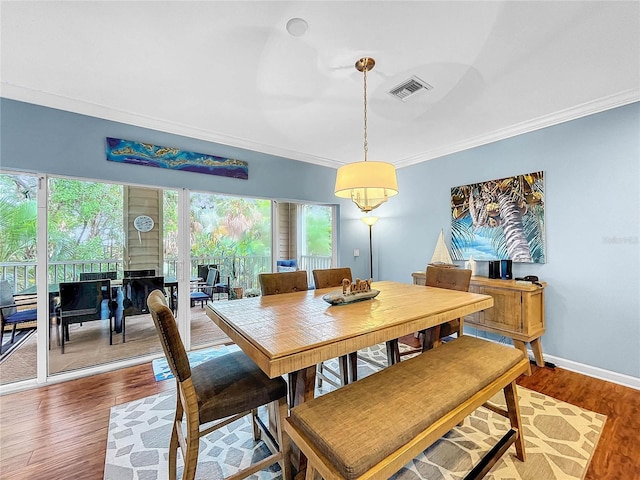 dining area featuring crown molding, hardwood / wood-style flooring, and a wealth of natural light