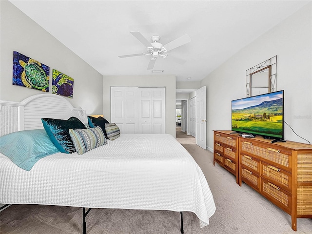 carpeted bedroom featuring ceiling fan and a closet