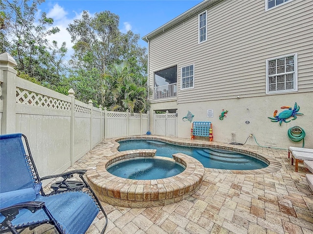 view of swimming pool featuring an in ground hot tub and a patio