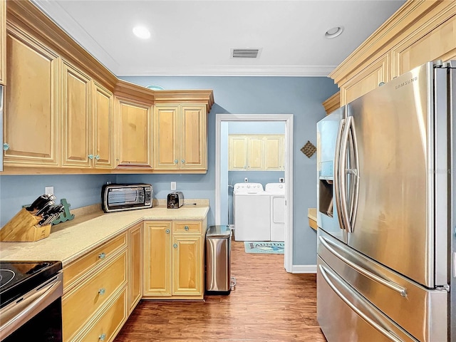 kitchen with crown molding, wood-type flooring, light brown cabinets, appliances with stainless steel finishes, and washing machine and dryer