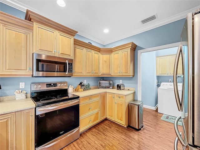 kitchen with stainless steel appliances, crown molding, light wood-type flooring, and independent washer and dryer