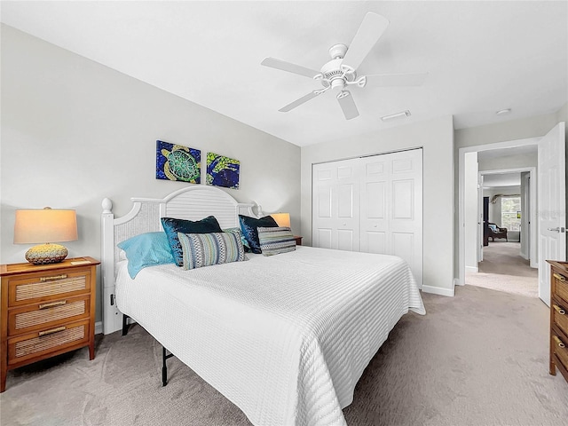 carpeted bedroom featuring ceiling fan and a closet