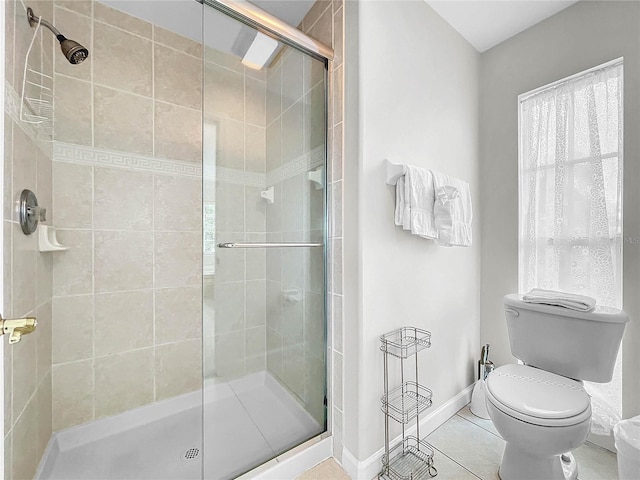 bathroom with plenty of natural light, tile patterned floors, toilet, and walk in shower