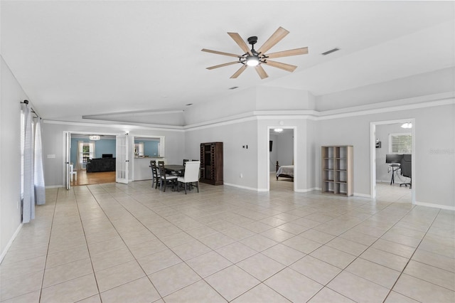 unfurnished living room featuring ceiling fan, light tile patterned floors, and vaulted ceiling