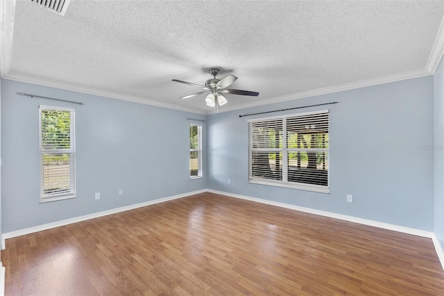 empty room with crown molding, hardwood / wood-style floors, ceiling fan, and plenty of natural light