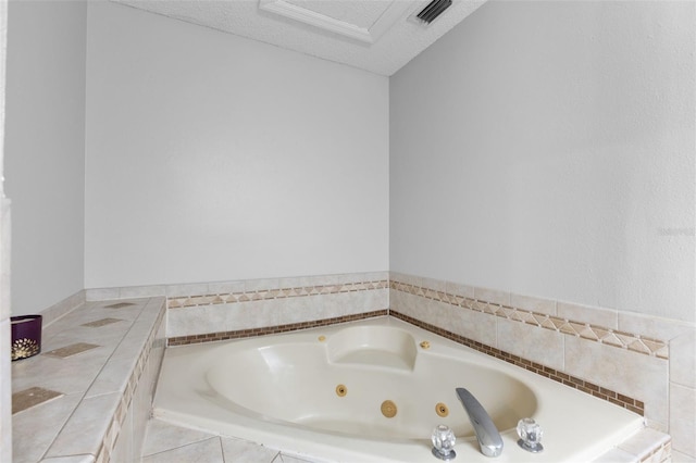 bathroom featuring tile patterned flooring, a textured ceiling, and tiled tub