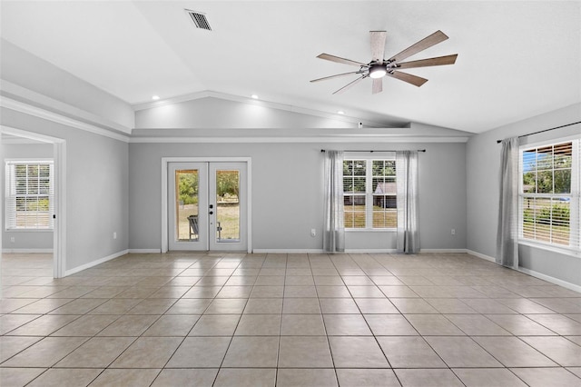 tiled spare room featuring ceiling fan, vaulted ceiling, a healthy amount of sunlight, and french doors