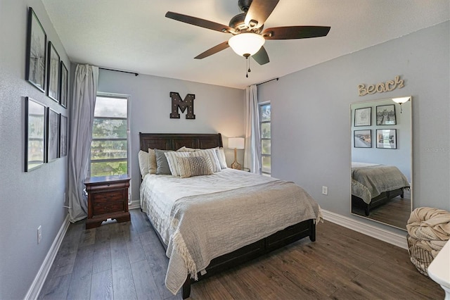 bedroom with multiple windows, ceiling fan, and dark hardwood / wood-style flooring